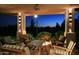 Evening view of covered patio with fire pit and comfortable seating at 15 Biltmore Estates Dr, Phoenix, AZ 85016