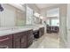 Double vanity bathroom with a walk-in shower and bedroom access at 42833 W Mallard Rd, Maricopa, AZ 85138
