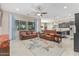 Open living area with leather sofas, large windows, and a ceiling fan at 42833 W Mallard Rd, Maricopa, AZ 85138