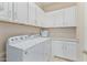 Laundry room with washer, dryer, and white cabinets at 42833 W Mallard Rd, Maricopa, AZ 85138