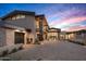 Modern home with stone and stucco exterior, large driveway, and landscaping at 38152 N 109Th St, Scottsdale, AZ 85262