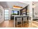 Modern wet bar with dark cabinetry, white countertops, and glass shelving at 38152 N 109Th St, Scottsdale, AZ 85262