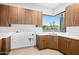 Laundry room with modern wood cabinets and a large window at 38152 N 109Th St, Scottsdale, AZ 85262