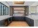 Modern wet bar with dark cabinets, wine storage, and a quartz countertop at 38152 N 109Th St, Scottsdale, AZ 85262