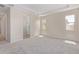 Spacious bedroom with carpet, ensuite bathroom access, and two windows at 23942 N 171St Dr, Surprise, AZ 85387
