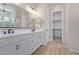 Modern bathroom with dual vanity, large mirror, and linen closet at 23942 N 171St Dr, Surprise, AZ 85387