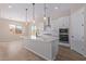 Open concept kitchen with island, white cabinets, and stainless steel appliances at 23942 N 171St Dr, Surprise, AZ 85387