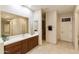 Bright bathroom with a vanity, large mirror, and access to other rooms at 6990 E Buckhorn Trl, Scottsdale, AZ 85266