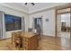 Bright home office with hardwood floors, large windows, and a view to the dining room at 6990 E Buckhorn Trl, Scottsdale, AZ 85266