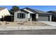 Single story home with gray exterior, two-car garage, and desert landscaping at 17463 N 66Th Ave, Glendale, AZ 85308