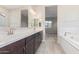 Elegant bathroom with double vanity, large mirror, and soaking tub at 16408 W Creedance Blvd, Surprise, AZ 85387