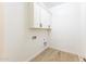 Bright laundry room with white cabinets and wood-look tile floor at 630 N Star Ct, Apache Junction, AZ 85119