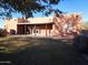 Back of the house with covered patio and grassy backyard at 25645 W Blue Sky Dr, Wittmann, AZ 85361