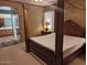Main bedroom with large four poster bed and ensuite bathroom at 25645 W Blue Sky Dr, Wittmann, AZ 85361