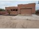 Spanish-style home with a two-car garage and desert landscaping at 25645 W Blue Sky Dr, Wittmann, AZ 85361