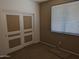 Simple bedroom with double door closet and window blinds at 25645 W Blue Sky Dr, Wittmann, AZ 85361