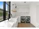 Modern laundry room with white cabinets and new appliances at 6512 E Hummingbird Ln, Paradise Valley, AZ 85253