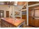 Open kitchen with wooden island, sink, and built-in microwave at 10040 E Happy Valley Rd # 676, Scottsdale, AZ 85255