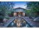 Elegant home exterior with stone facade and a water feature in front at 865 E Monte Vista Trl, Wickenburg, AZ 85390