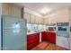 Retro kitchen with red cabinets, green refrigerator, and built-in oven at 8421 E Main St # 106, Mesa, AZ 85207