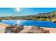 Stunning infinity pool with mountain views and rock landscaping at 11108 E Mariola Way, Scottsdale, AZ 85262