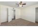 Spacious bedroom with carpeted floor, ceiling fan, and access to hallway at 1401 E Osborn Rd, Phoenix, AZ 85014