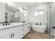 Modern bathroom with double vanity, soaking tub, and glass shower at 31712 N 169Th Ave, Surprise, AZ 85387
