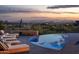 Modern pool and patio with lounge chairs and beautiful mountain views at sunset at 41851 N 112Th Pl, Scottsdale, AZ 85262