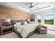 Bright main bedroom features a king-size bed, wood accent wall, and golf course views at 37200 N Cave Creek Rd # 2124, Scottsdale, AZ 85262