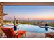 Relaxing patio with infinity pool, spa, and sunset views at 11070 E Rolling Rock Dr, Scottsdale, AZ 85262