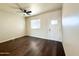 Living area with dark wood-like flooring, ceiling fan, and a door leading to the exterior at 4030 N Palm Cir, Eloy, AZ 85131