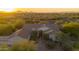 Aerial view of a single-story house with desert landscaping and mountain views at sunset at 39012 N 8Th St, Phoenix, AZ 85086