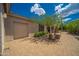 Tan colored house exterior with a two-car garage and nicely landscaped yard at 39012 N 8Th St, Phoenix, AZ 85086