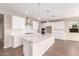 Modern kitchen with white cabinets, quartz countertops, and stainless steel appliances at 40387 W Michaels Dr, Maricopa, AZ 85138