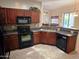 Updated kitchen featuring dark wood cabinets, black appliances, and double sink at 2101 S Meridian Rd # 34, Apache Junction, AZ 85120