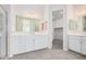 Modern bathroom with double vanity, a large mirror, and grey tile flooring at 24041 N 171St Ln, Surprise, AZ 85387