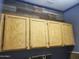 Laundry room with wood cabinets and a rustic reclaimed wood accent wall at 6547 E Sierra Morena St, Mesa, AZ 85215
