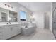 Modern bathroom with double vanity, soaking tub, and walk-in shower at 24030 N 171St Dr, Surprise, AZ 85387