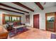 Living area with exposed wood beams and a leather couch at 10284 E Filaree Ln, Scottsdale, AZ 85262