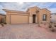 Tan house with a two-car garage and well-manicured landscaping at 20245 W Catalina Dr, Buckeye, AZ 85396