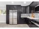 Modern kitchen with dark cabinetry, stainless steel appliances, and quartz countertops at 2033 W Sunnyside Ave, Phoenix, AZ 85029