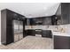 Modern kitchen with dark cabinetry, stainless steel appliances, and quartz countertops at 2033 W Sunnyside Ave, Phoenix, AZ 85029