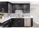 Modern kitchen with dark cabinetry, stainless steel appliances, and quartz countertops at 2033 W Sunnyside Ave, Phoenix, AZ 85029