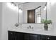 Modern bathroom with a large mirror, dark vanity, and contemporary lighting at 11475 E Paradise Ln, Scottsdale, AZ 85255