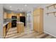 Modern kitchen with light wood cabinets, granite countertops, and black appliances at 3704 W Vivian Ct, Phoenix, AZ 85086