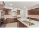 Modern kitchen featuring dark wood cabinets and a large island with a sink at 17065 W Molly Ln, Surprise, AZ 85387
