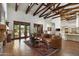 Spacious great room with wood beams, hardwood floors, access to pool, and comfortable seating at 5842 E Redwing Rd, Paradise Valley, AZ 85253