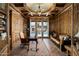 Home office with built-in bookshelves, hardwood floors, and pool view at 5842 E Redwing Rd, Paradise Valley, AZ 85253