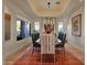 Bright dining room featuring a large table, statement lighting, and hardwood floors at 10751 E Candlewood Dr, Scottsdale, AZ 85255