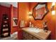 Unique powder room with orange walls and star mirror at 10751 E Candlewood Dr, Scottsdale, AZ 85255